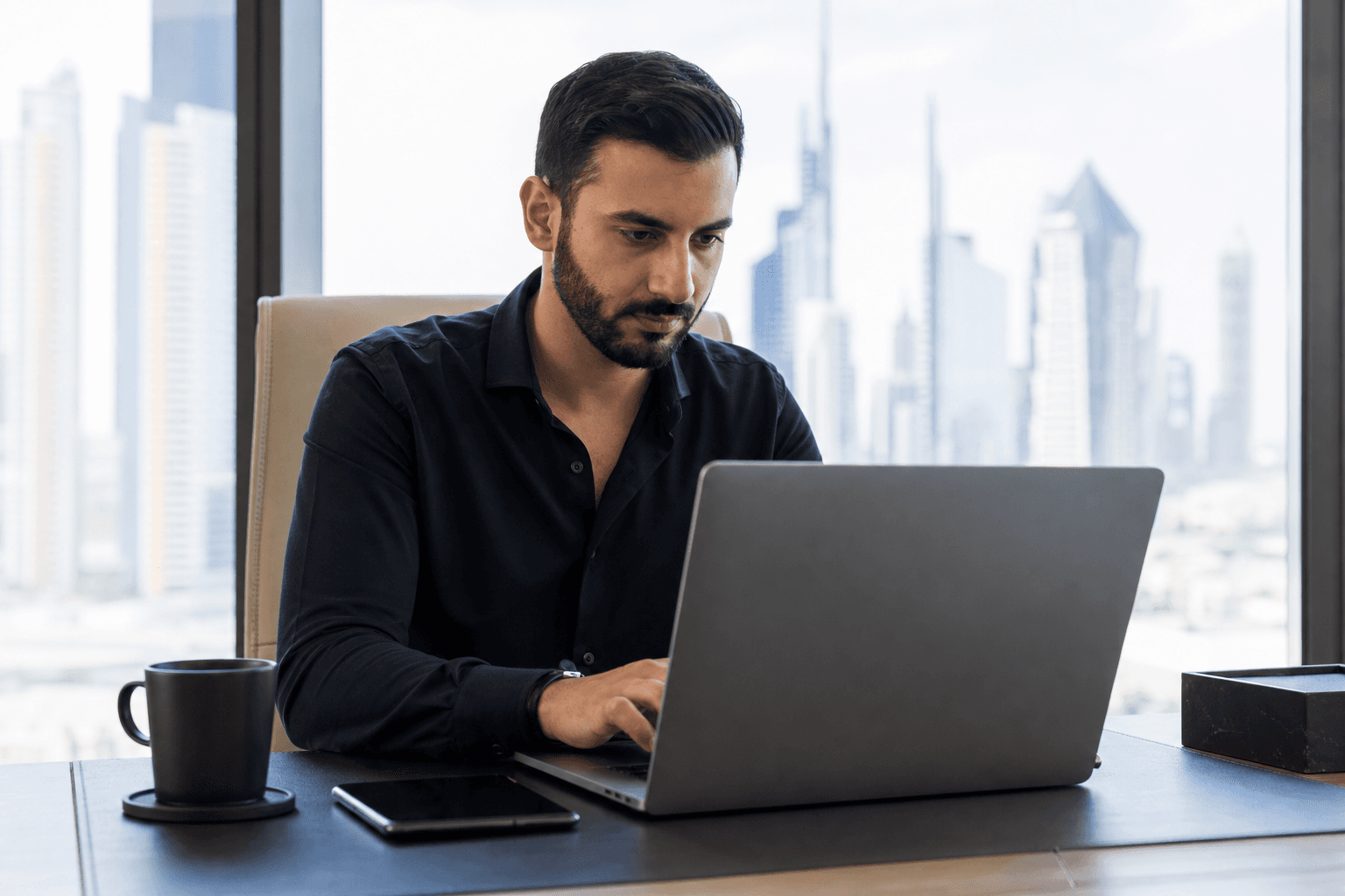 Unternehmer arbeitet am Laptop mit Blick auf Dubai