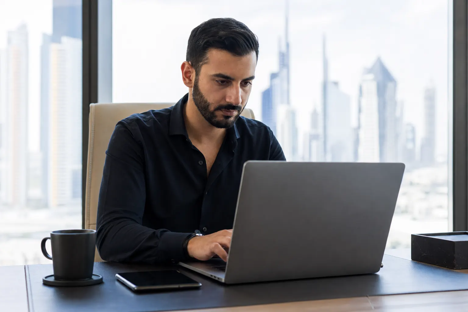 Entrepreneur working on a laptop with a view of Dubai